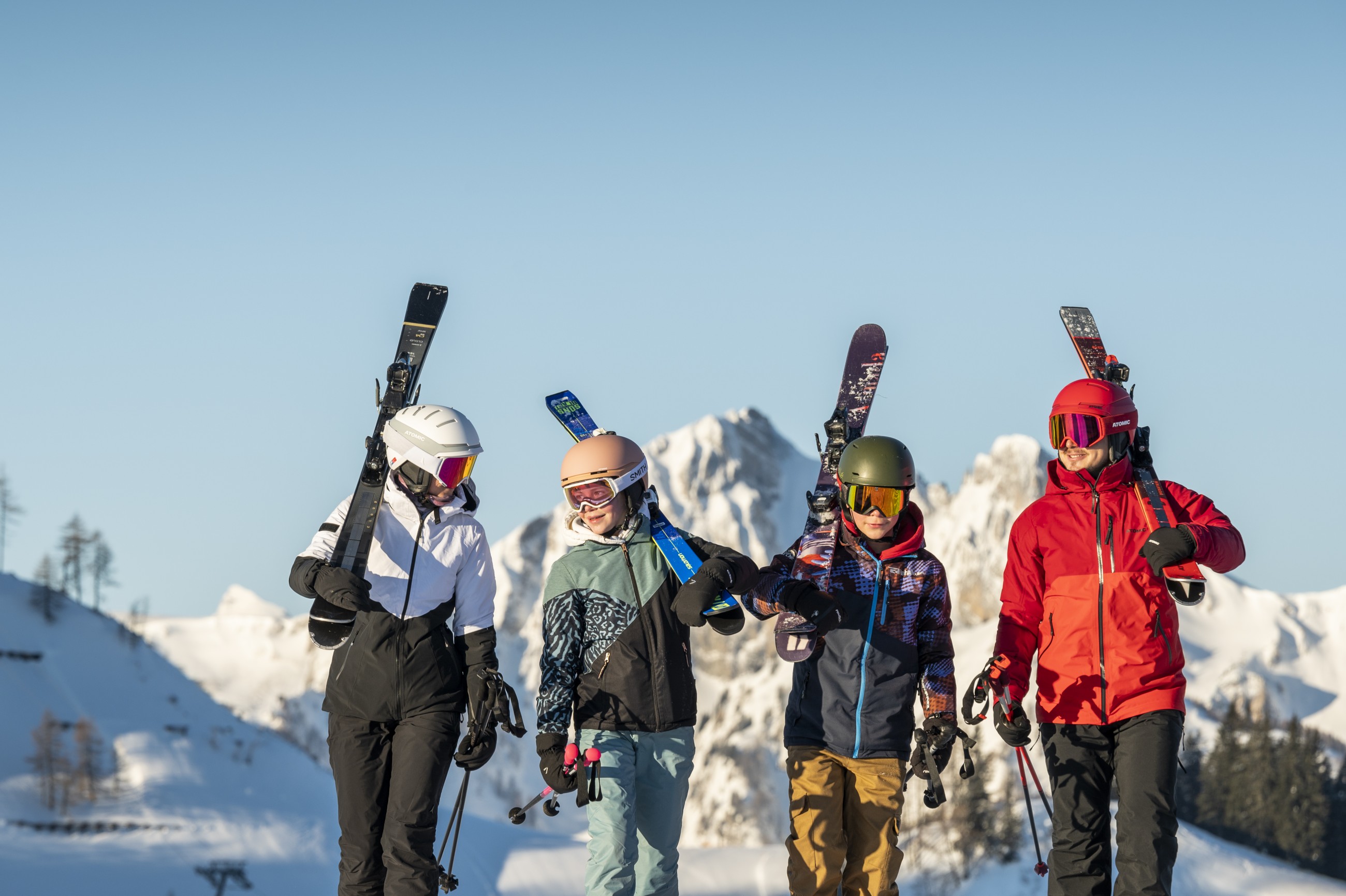 Familie beim Skifahren auf der Piste mit Ski auf der Schulter &copy; LorenzMasser