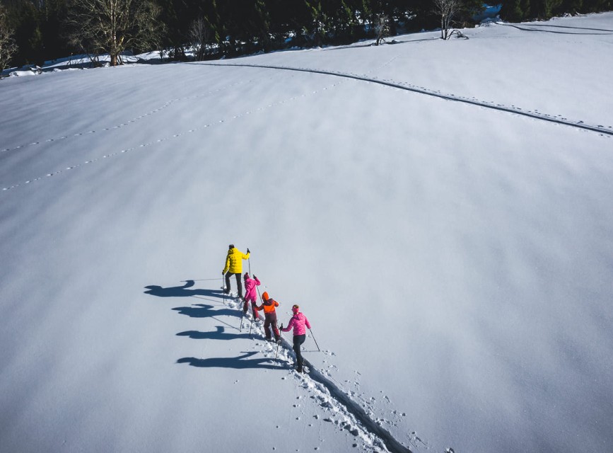 Familie beim Schneeschuhwandern durch die verschneite Winterlandschaft in Kleinarl © Christian Schartner