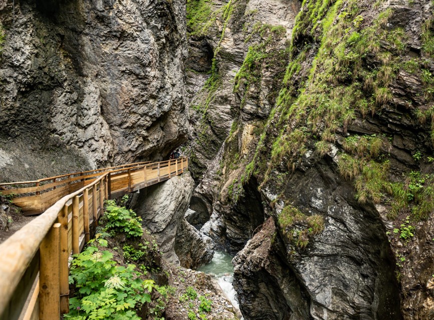 Holzsteg durch die beeindruckende Lichtensteinklamm in St. Johann im Pongau, umgeben von steilen Felswänden und rauschendem Wasser © Tourismusverband St. Johann in Salzburg
