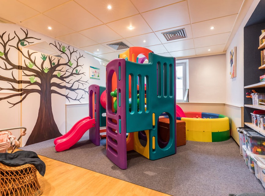 Indoor-Spielraum mit Kletterturm und Rutsche im Familienhotel Botenwirt
