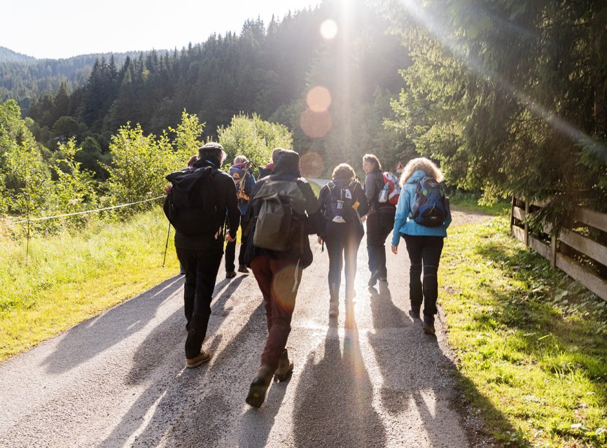 Zwei Wanderer sitzen auf einer Bank und genießen den Bergblick bei Sonnenuntergang in Kleinarl © Wagrain-Kleinarl /Amanda Schmidt