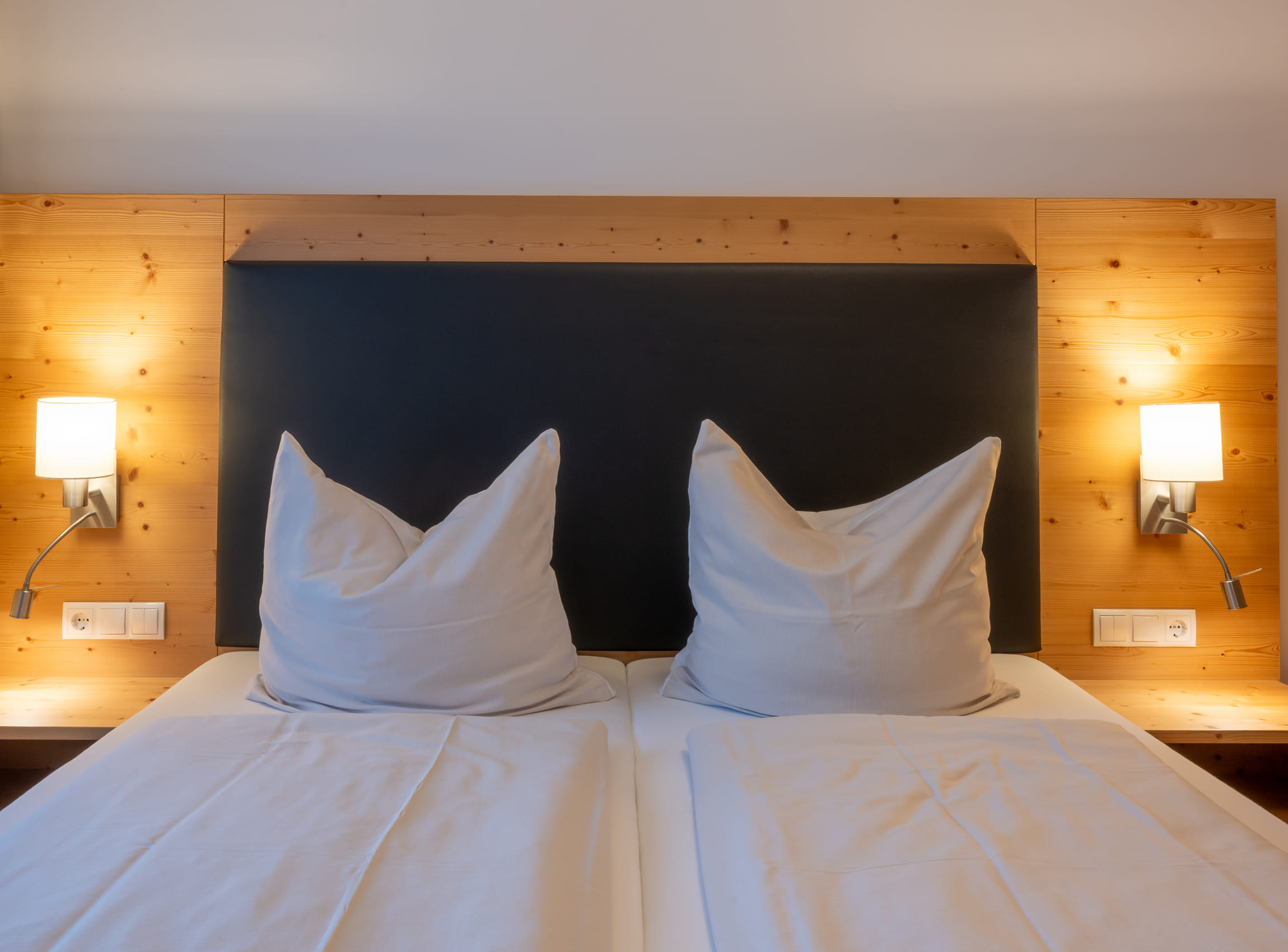 Cozy hotel bed in a guest room at Familienhotel Botenwirt