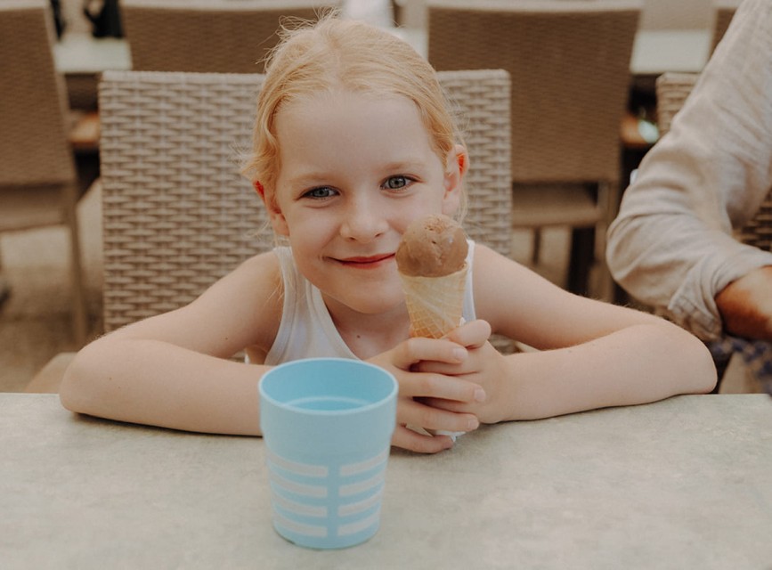Kind isst ein Eis im Garten des Hotels Botenwirt