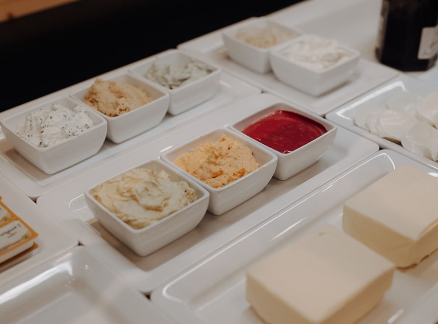 Frühstückstisch mit verschiedenen Speisen wie Obst, Schinken, Eiern und Saft