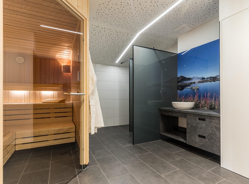 Sonnenliegen und Sonnenschirme am Naturbadeteich im Salzburgerland