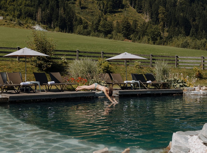 Frau springt in den Naturbadeteich des Botenwirt &ndash; Sommerurlaub in Kleinarl